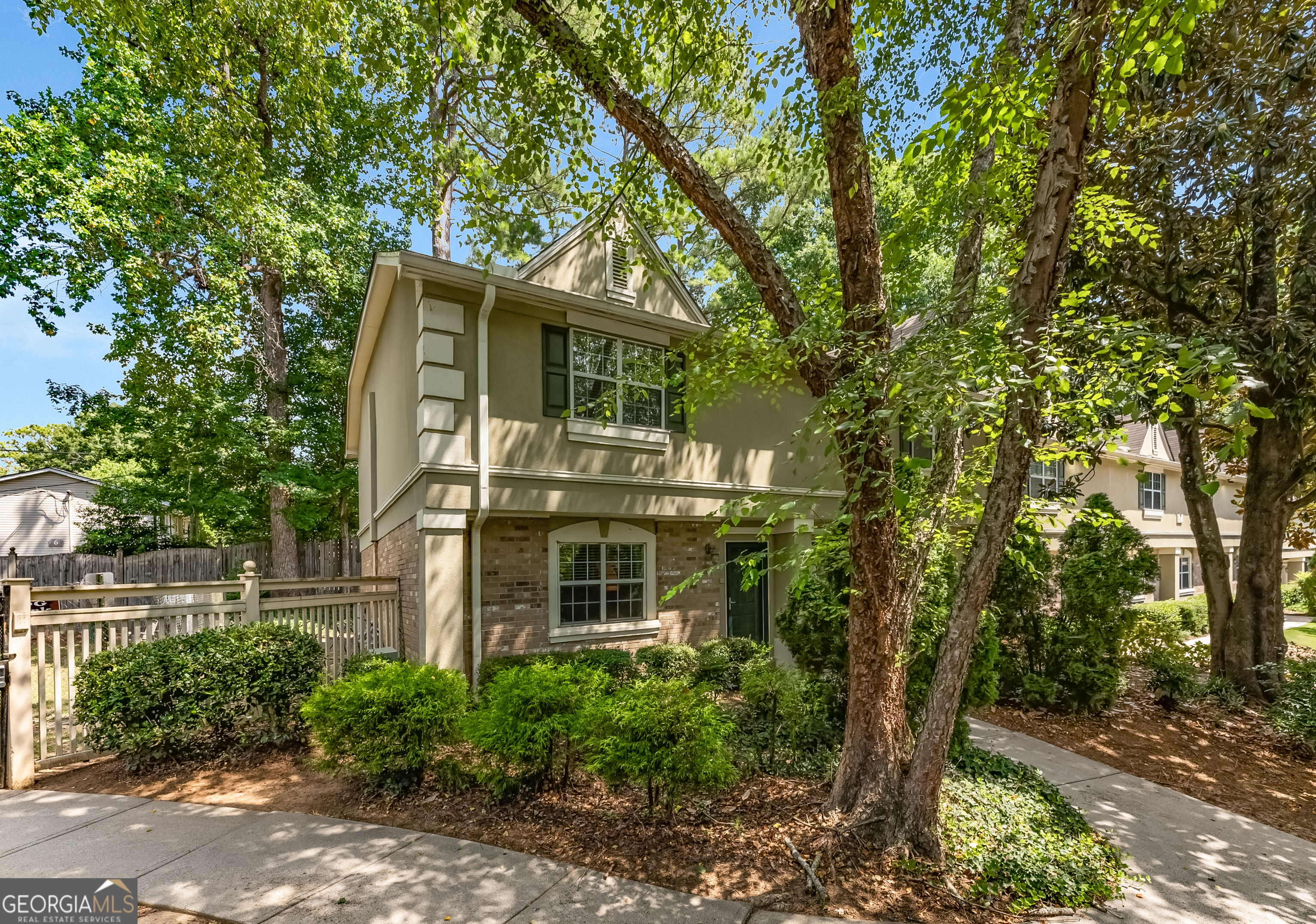 a front view of a house with a tree