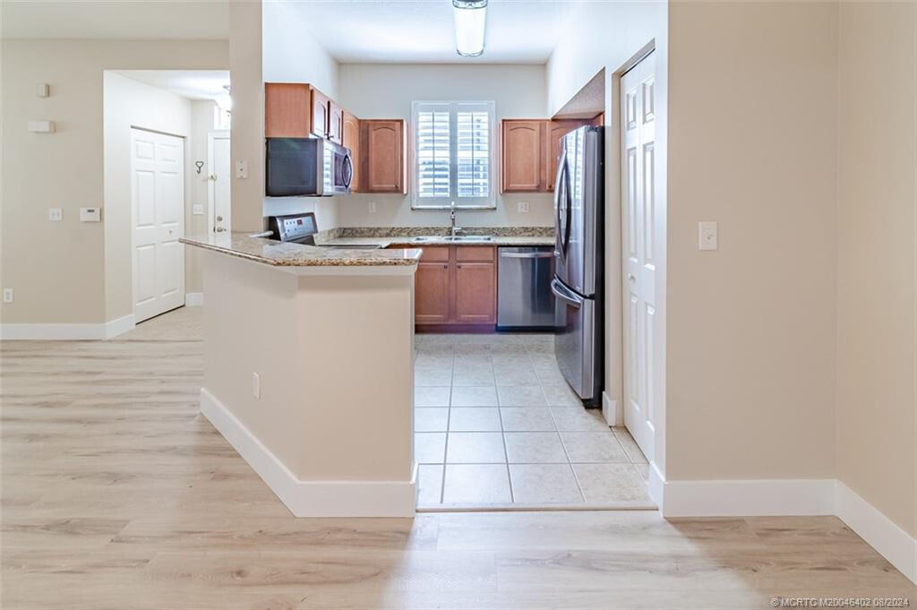 a kitchen with stainless steel appliances granite countertop a refrigerator and a sink