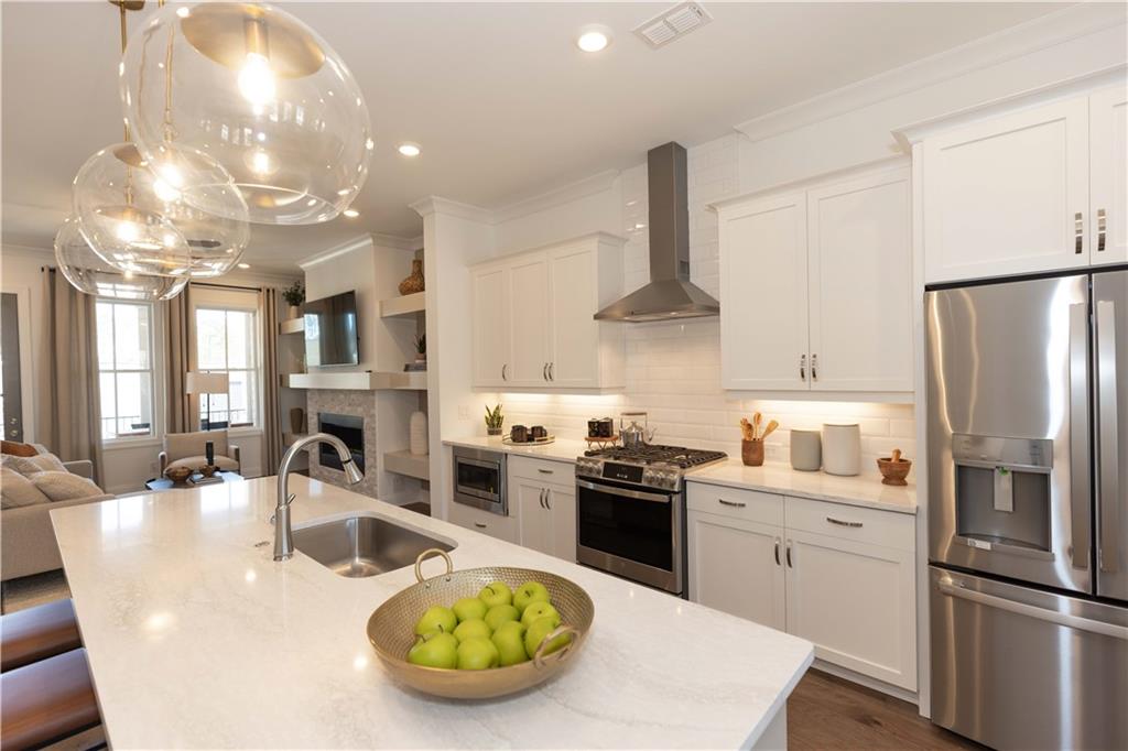 a kitchen with stainless steel appliances granite countertop a sink a stove and a refrigerator