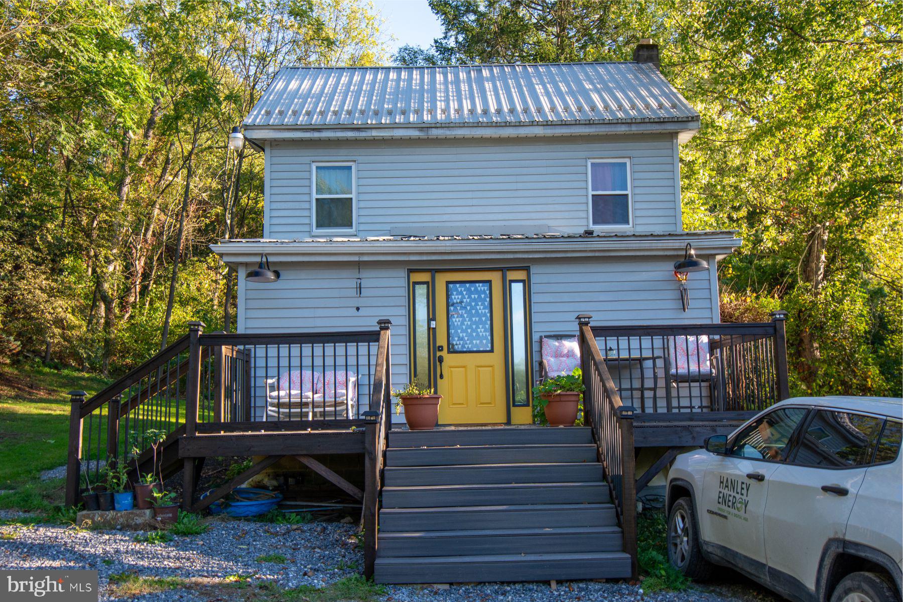 a view of a house with wooden deck and furniture