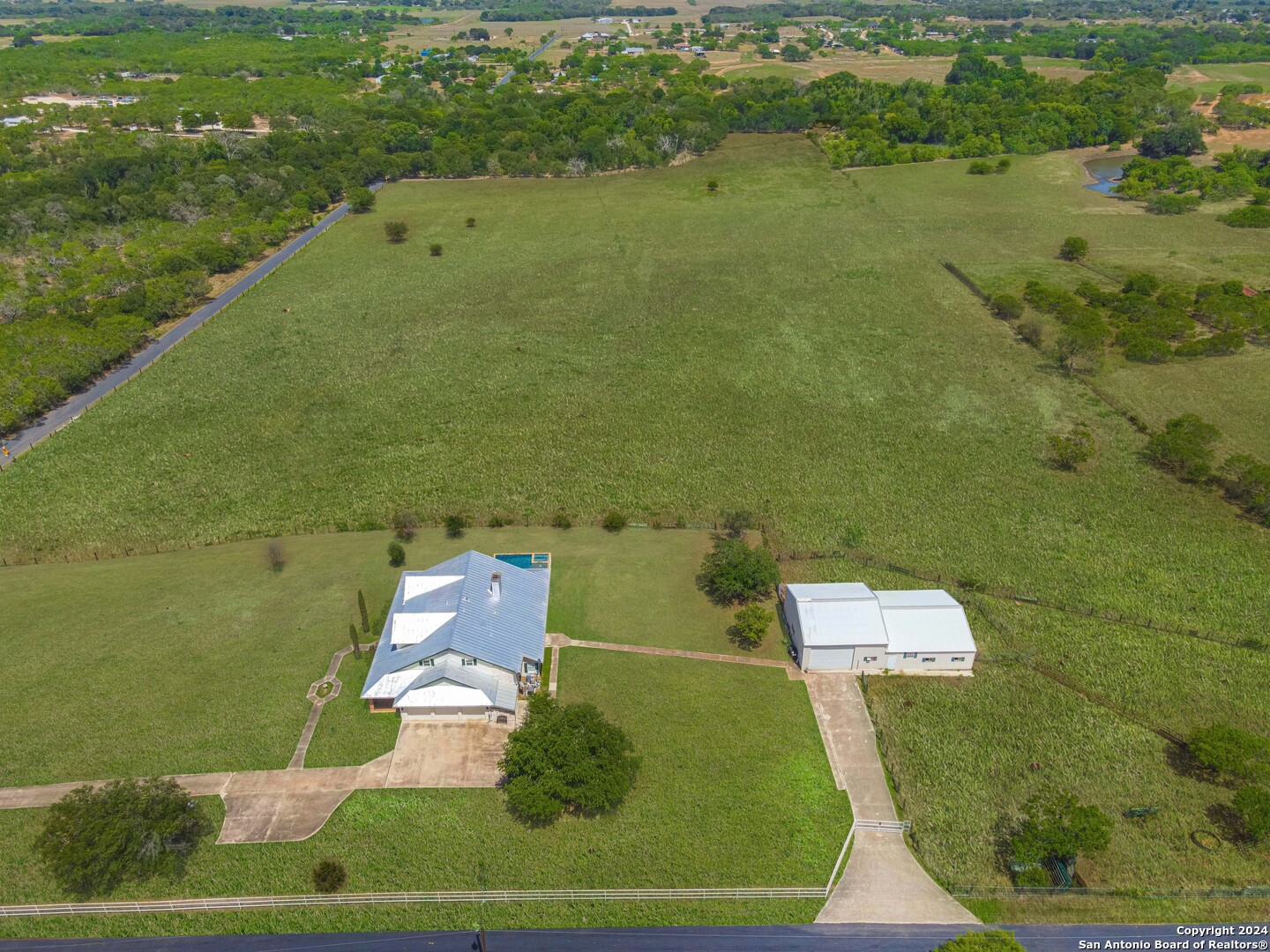 an aerial view of a house with a yard and lake view