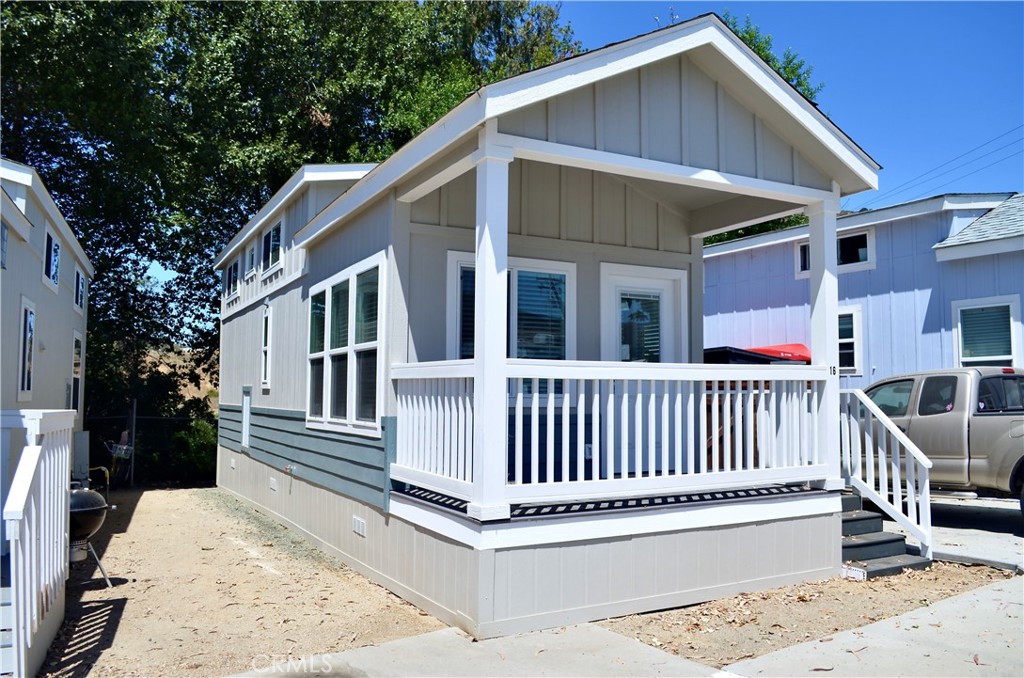 a porch with a bench next to a yard