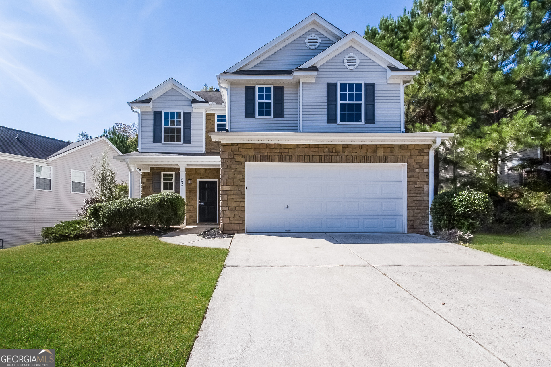 a front view of a house with a yard and garage