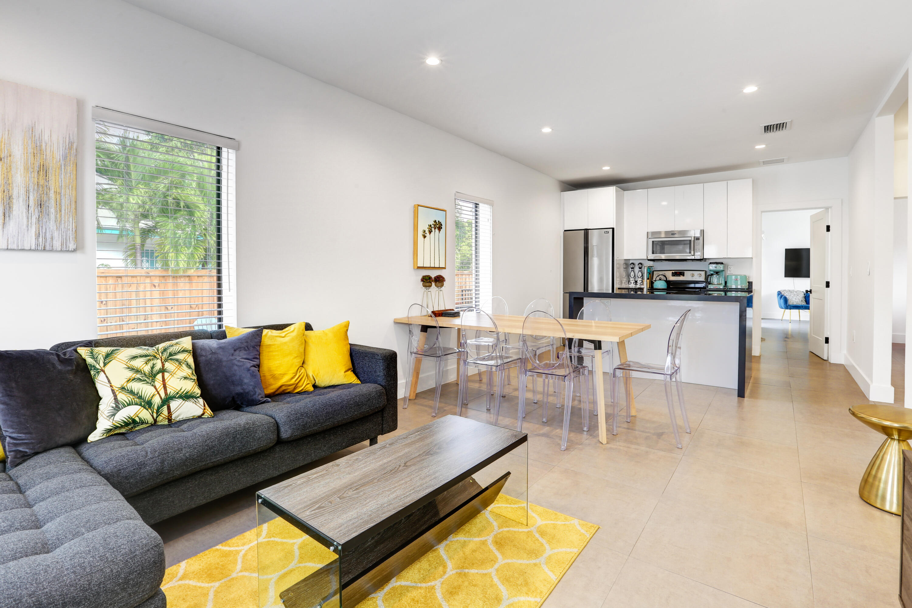 a living room with stainless steel appliances furniture and a kitchen view