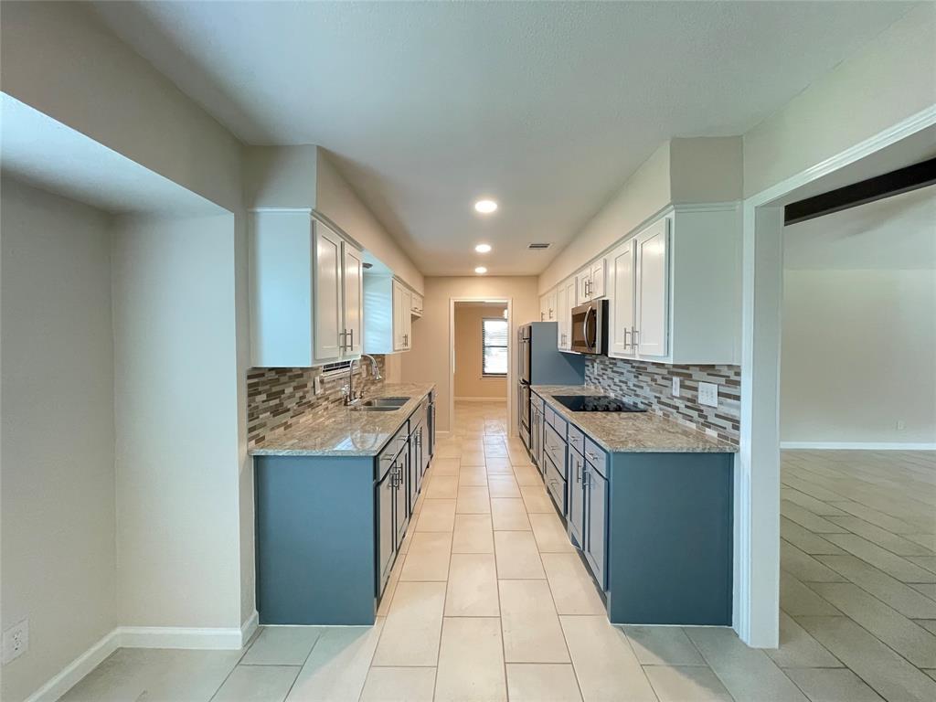 a large kitchen with stainless steel appliances granite countertop a stove and a refrigerator