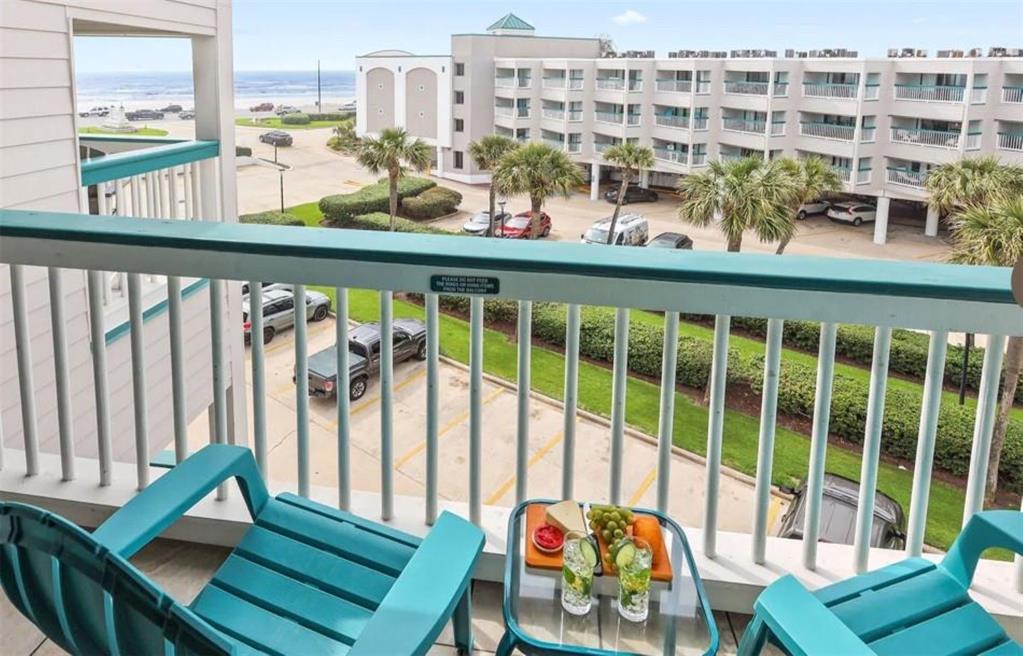 a view of a balcony with chairs and a potted plant