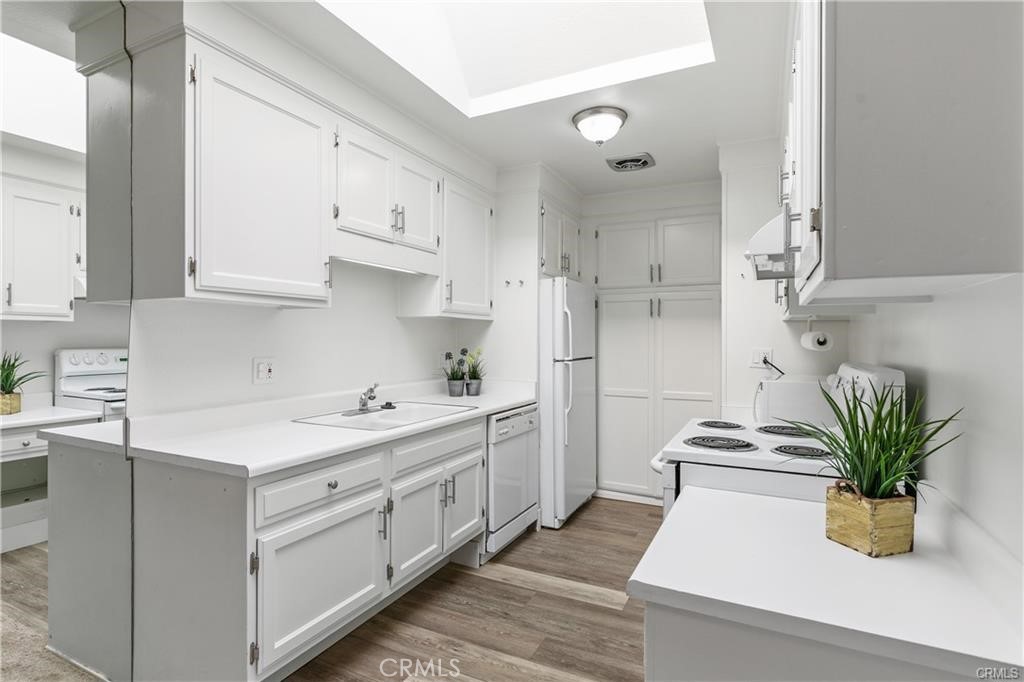 a kitchen with a white stove top oven and white cabinets