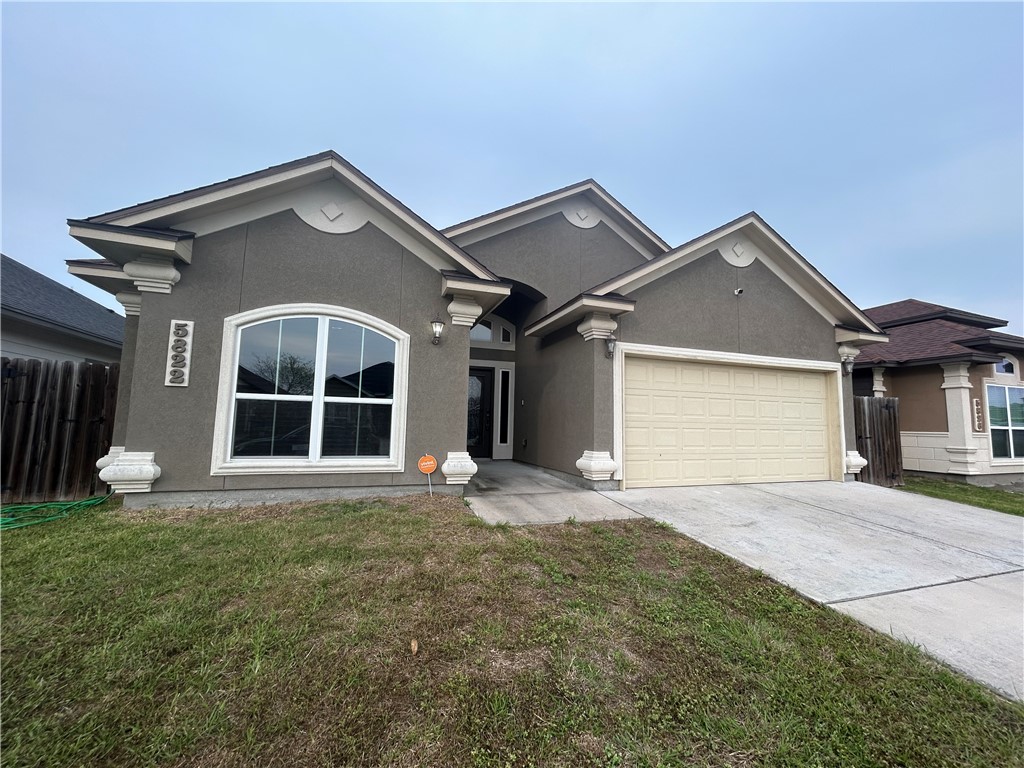 a front view of a house with a yard and garage