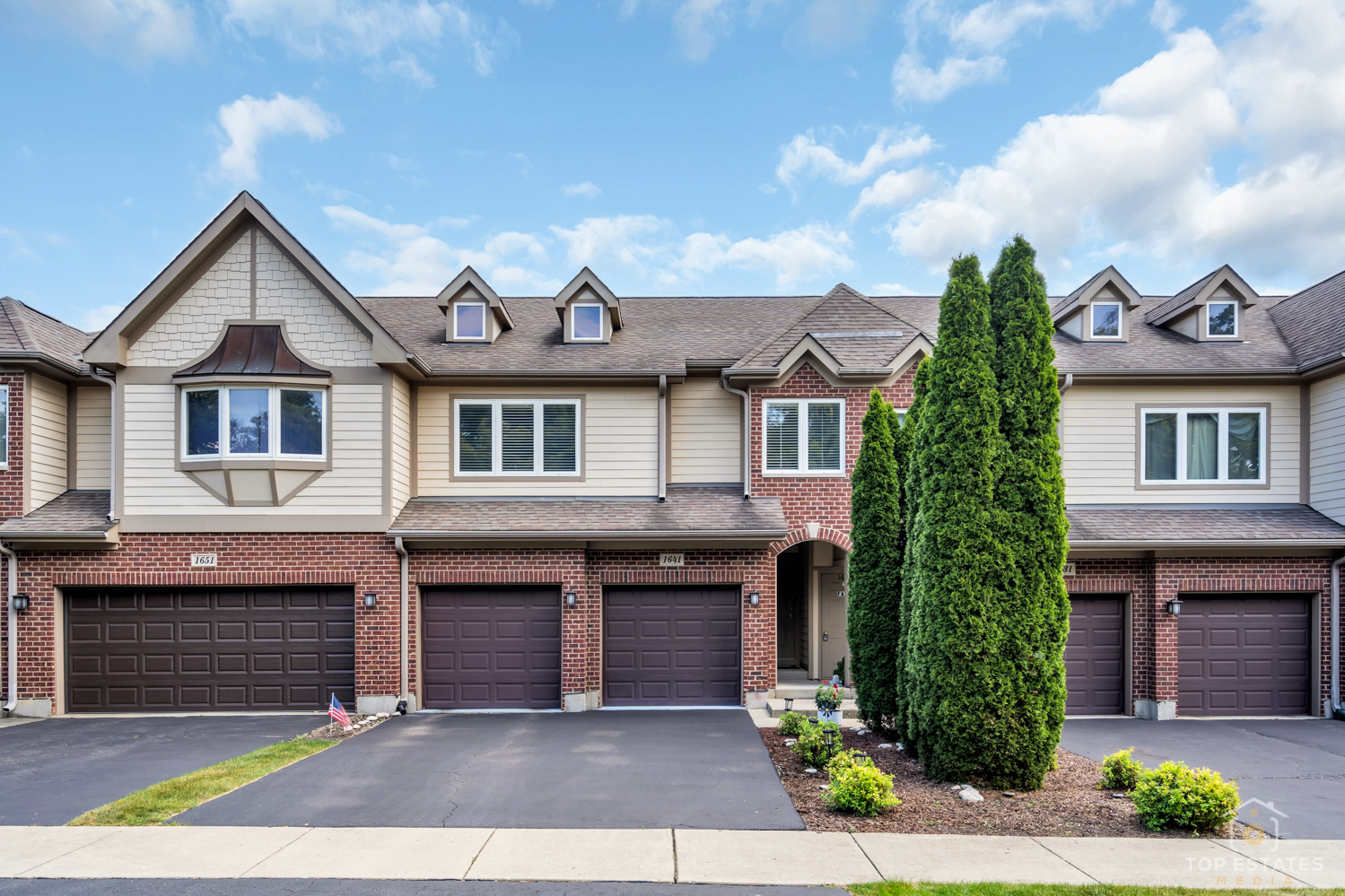 a front view of a house with yard and parking