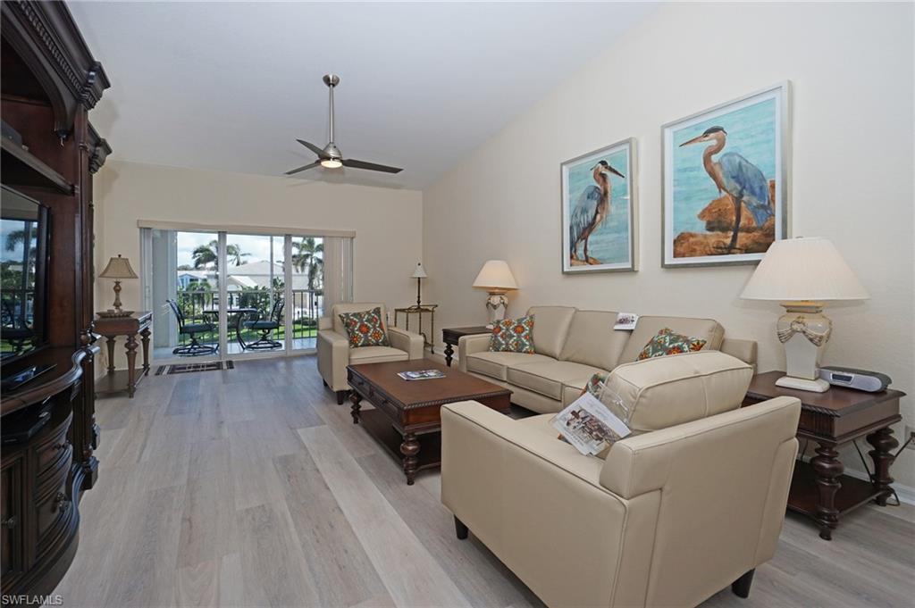 a living room with furniture a flat screen tv and a floor to ceiling window