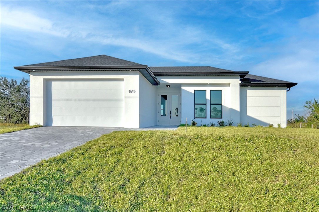 a front view of a house with a yard and garage