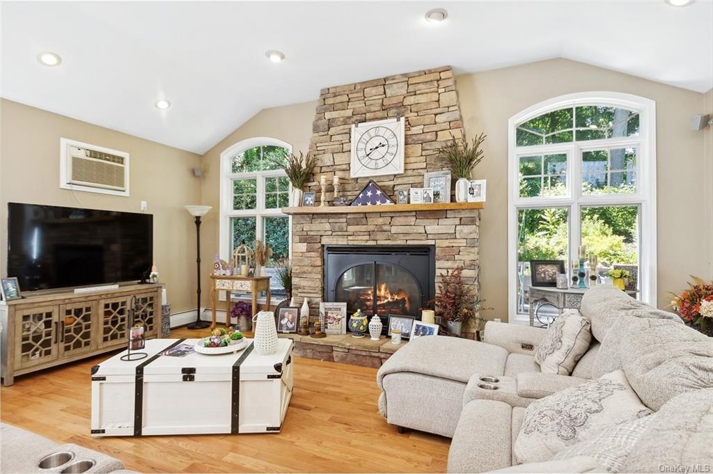 a living room with furniture a flat screen tv and a fireplace