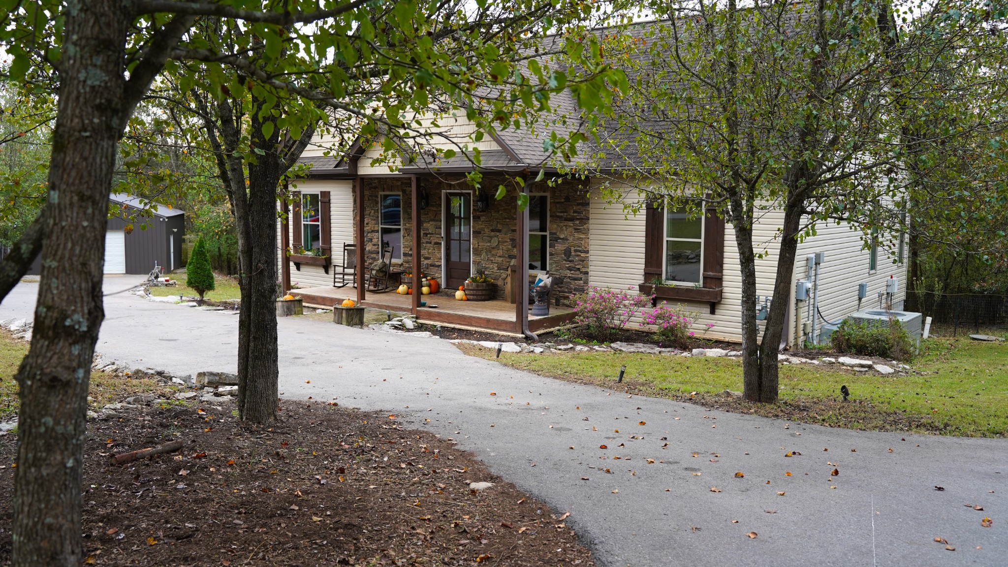 a front view of a house with a tree in front