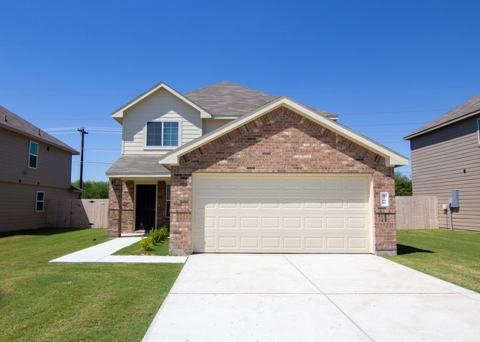 a front view of a house with a yard and garage