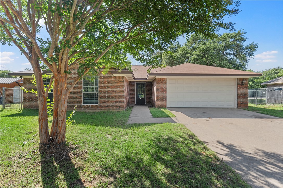 a front view of a house with a yard and a garage