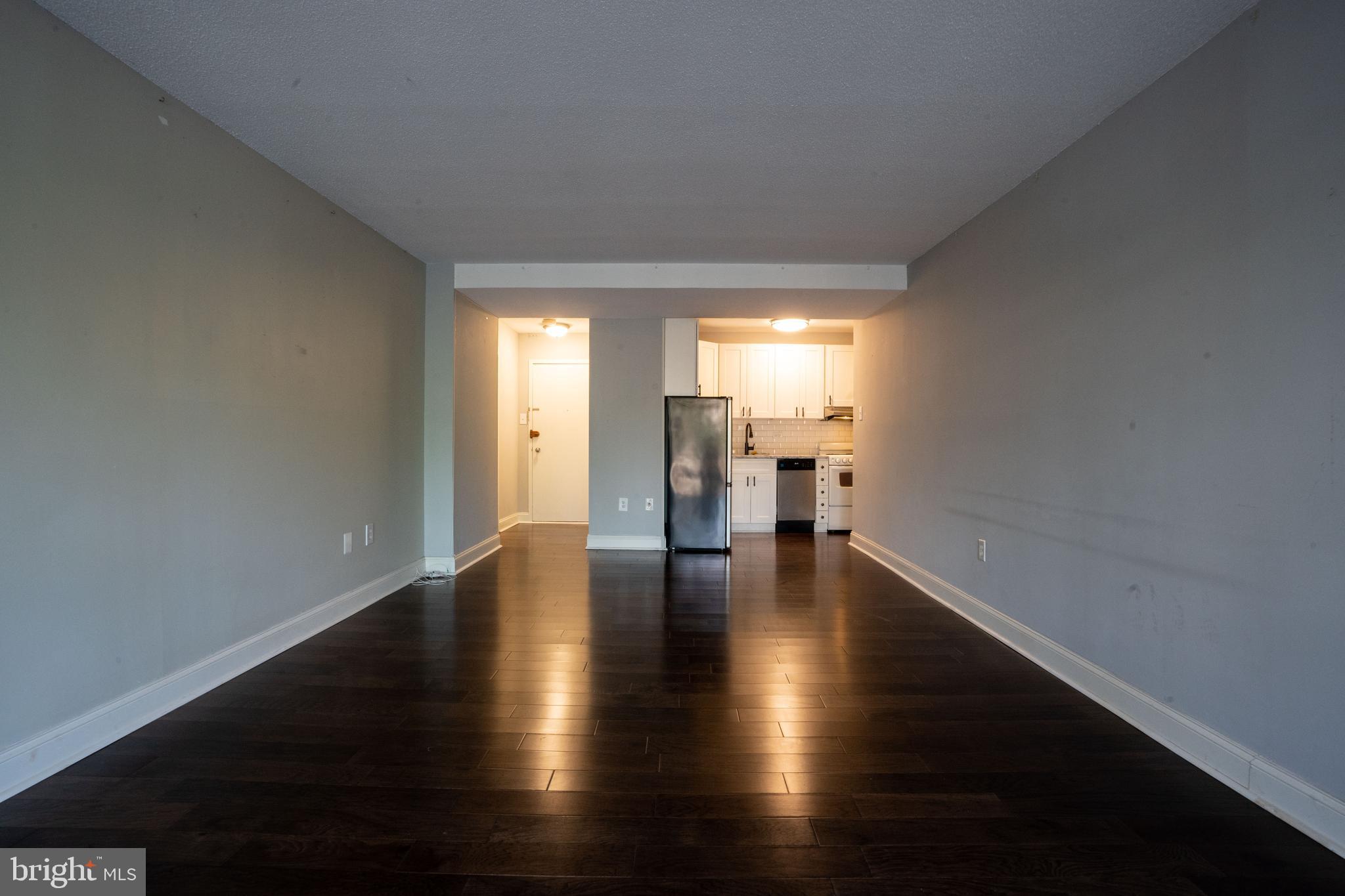 a view of empty room with wooden floor