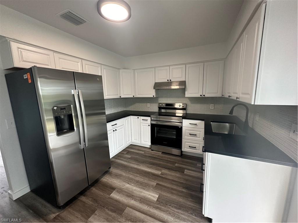 a kitchen with stainless steel appliances a refrigerator sink and stove