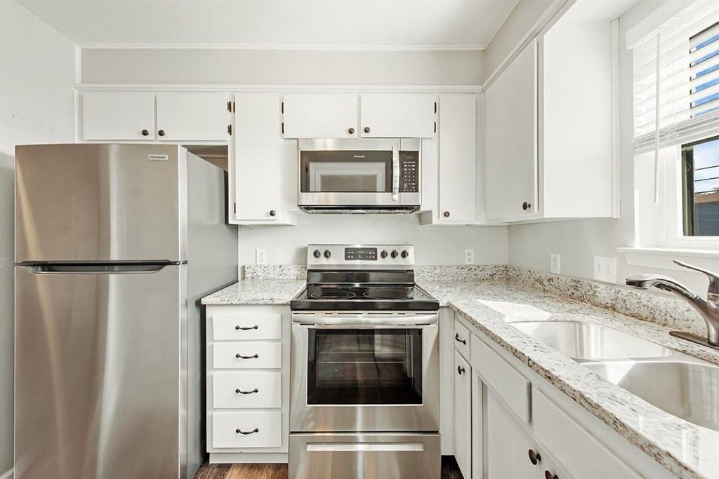 a kitchen with cabinets stainless steel appliances and a sink