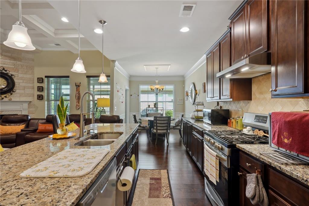 a open kitchen with stainless steel appliances granite countertop a lot of counter space and living room