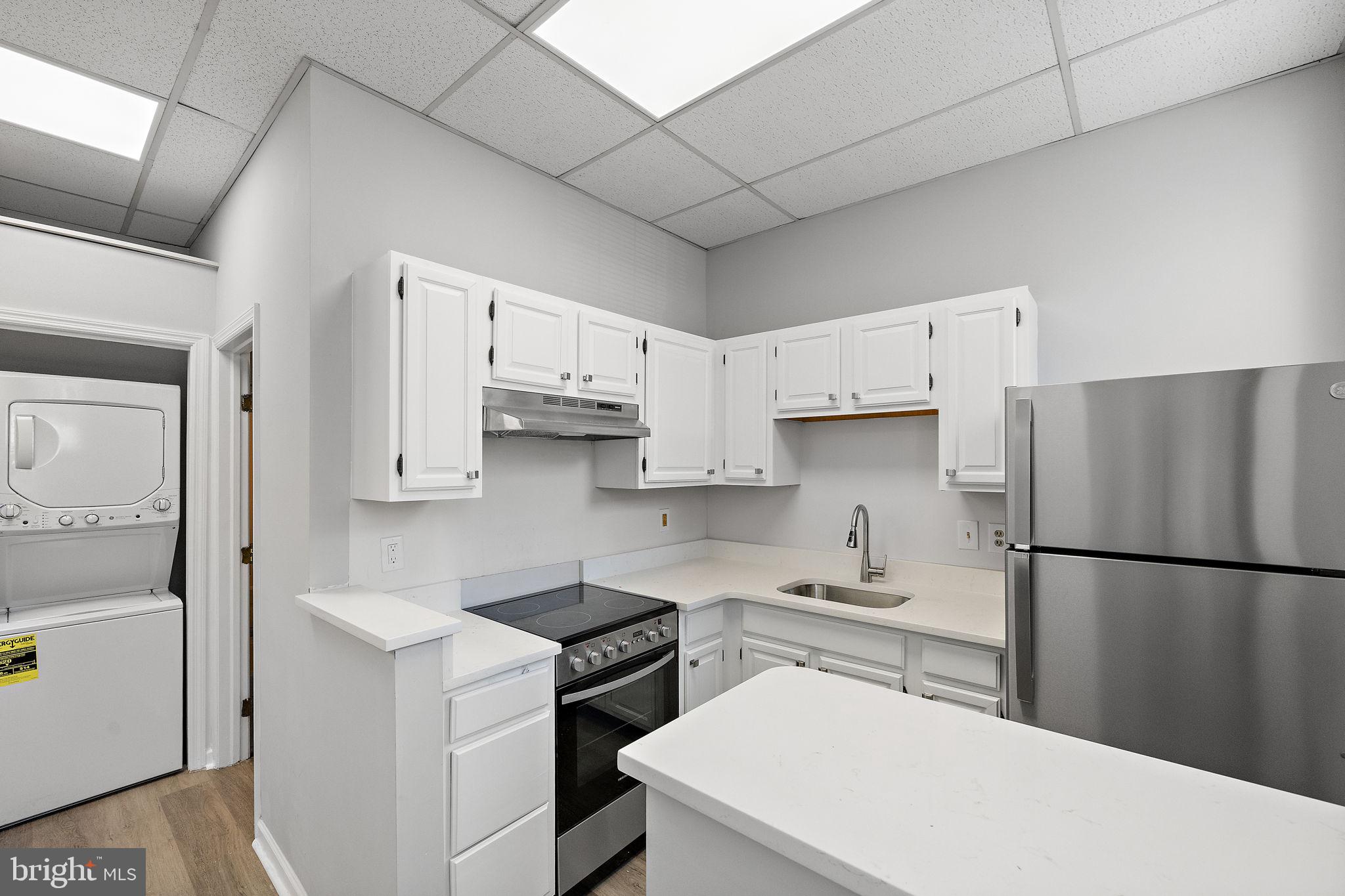 a kitchen with stainless steel appliances a refrigerator sink and white cabinets