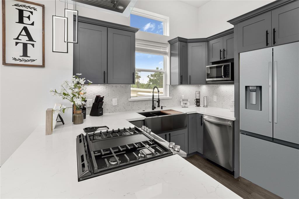 a kitchen with granite countertop a refrigerator stove and sink