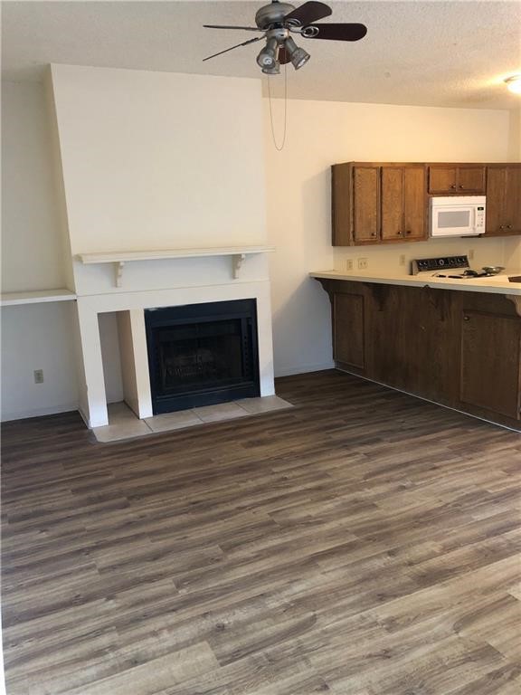 a view of kitchen and empty room with wooden floor