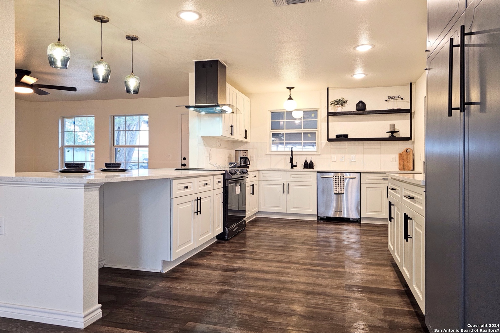 a kitchen with stainless steel appliances kitchen island granite countertop a sink a stove and refrigerator