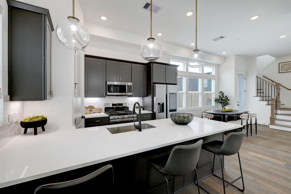 a kitchen with a dining table chairs sink and cabinets