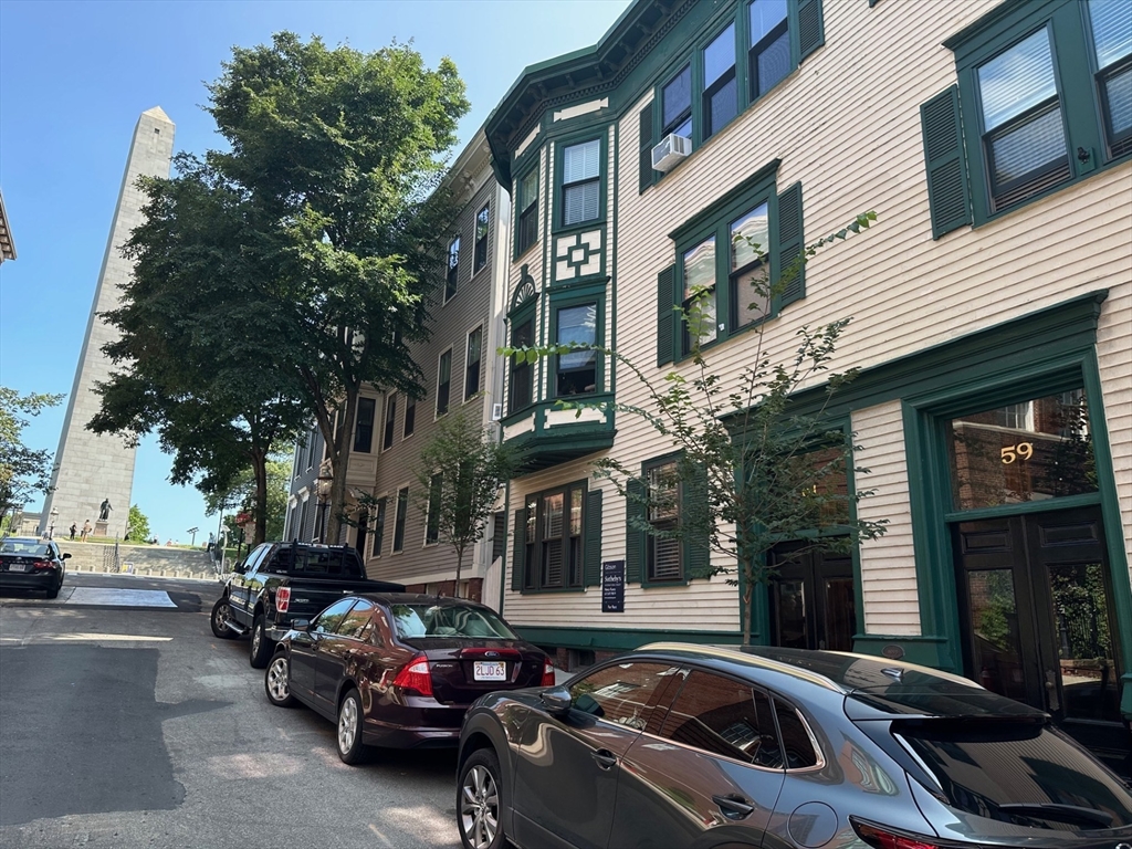 a couple of cars parked in front of a building