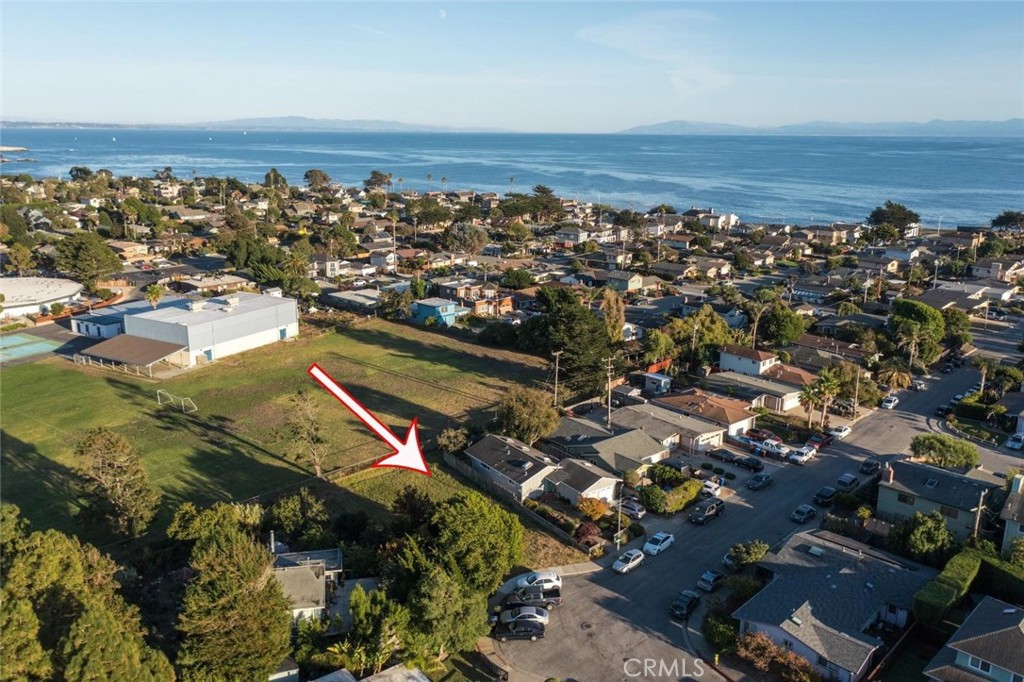 an aerial view of a city with lots of residential buildings and ocean view in back