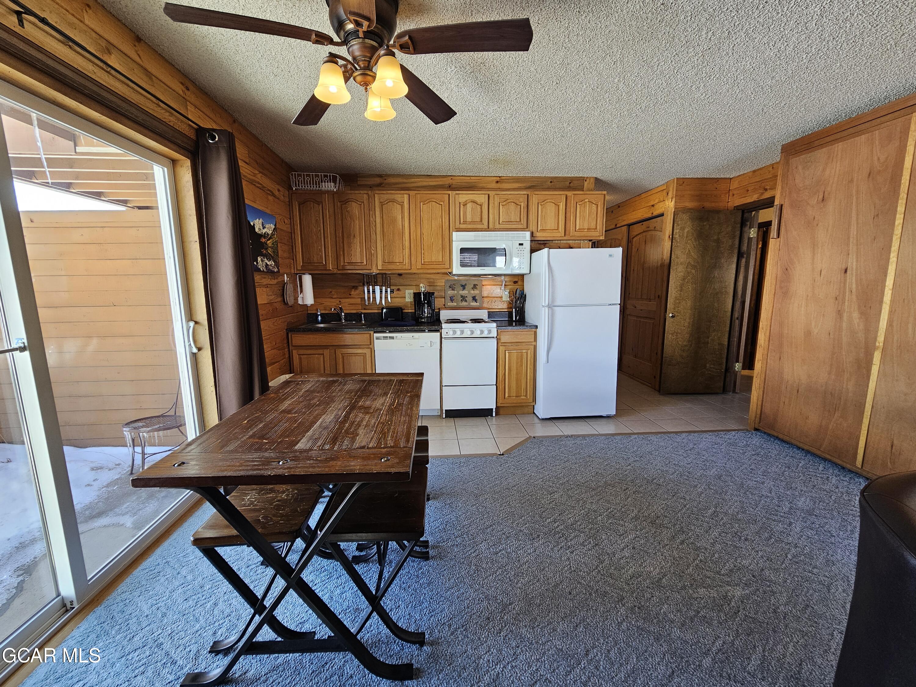 a kitchen with refrigerator and chairs