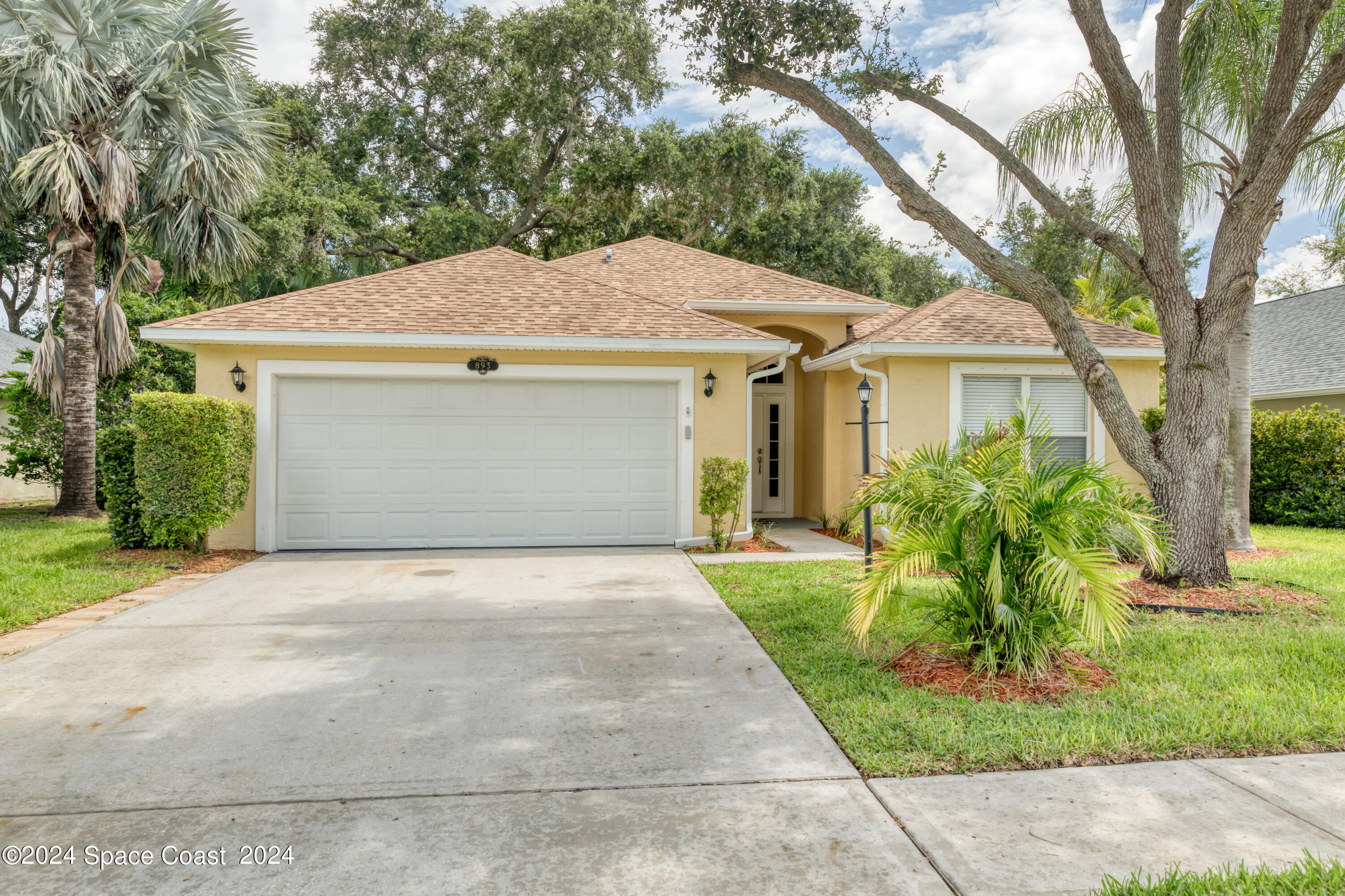 a front view of a house with a yard and trees