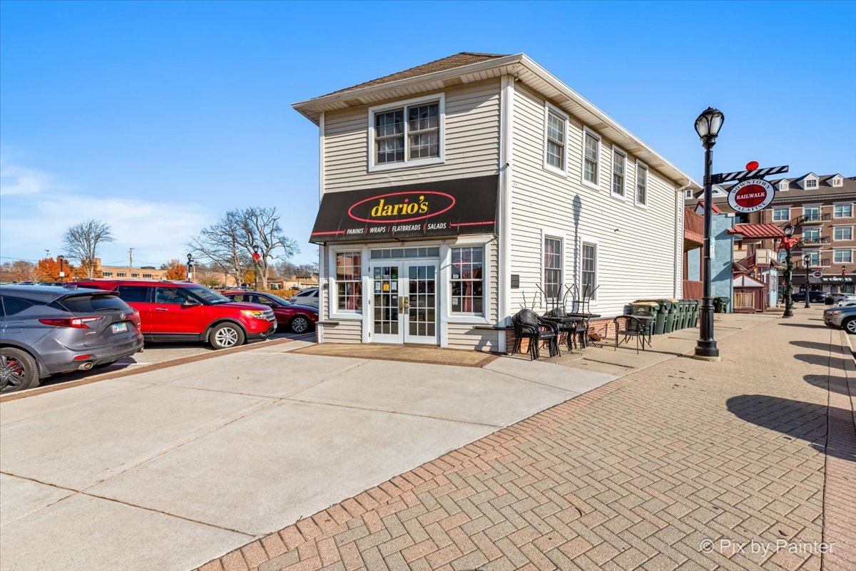 a front view of a building with lots of cars on city street