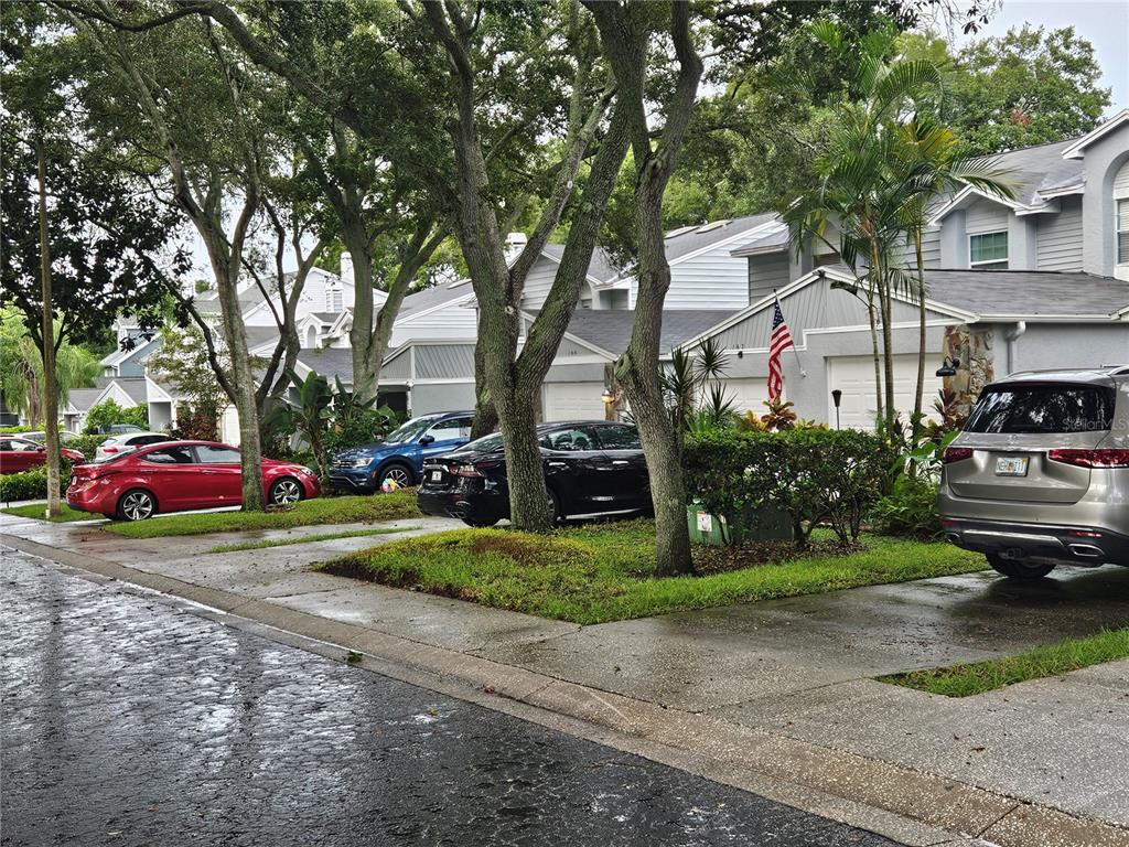 a front view of a house with a yard and car parked