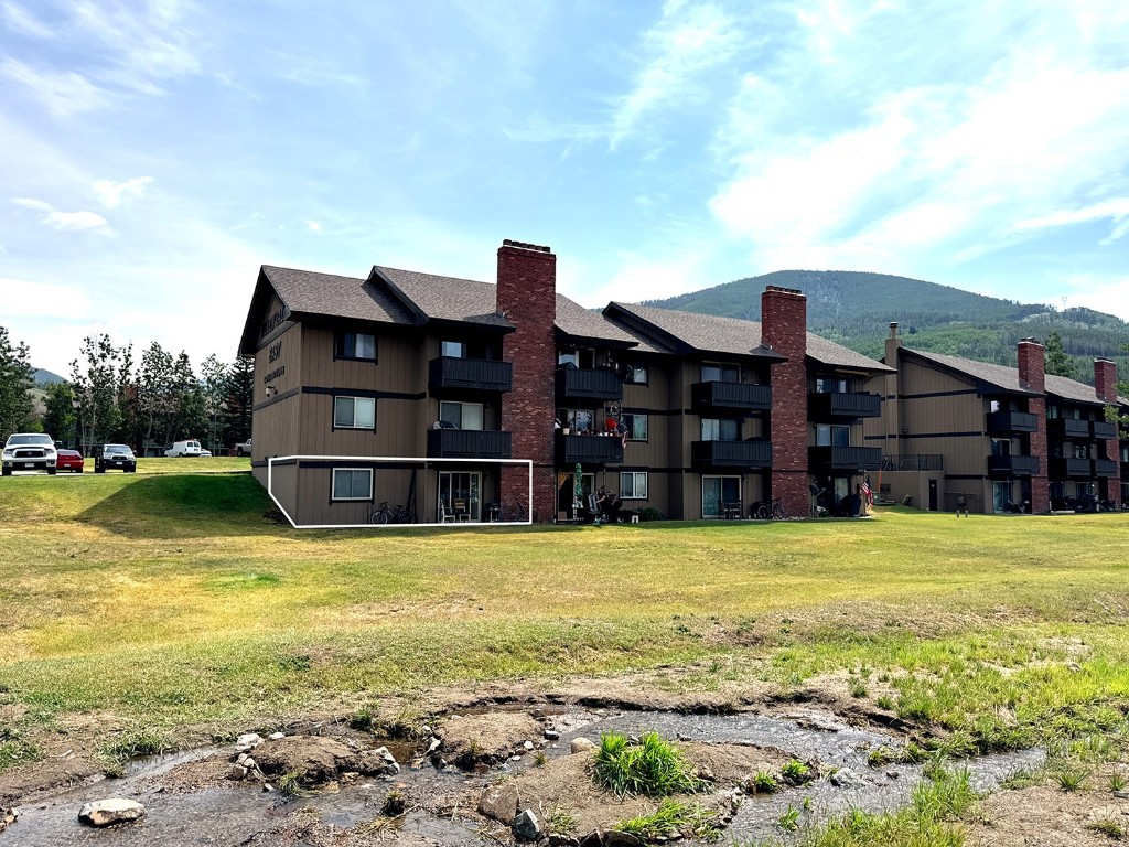 a view of a large building with a big yard and large trees