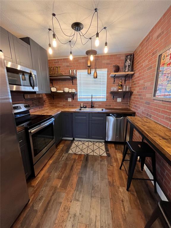 a large kitchen with stainless steel appliances granite countertop a stove and a wooden floors