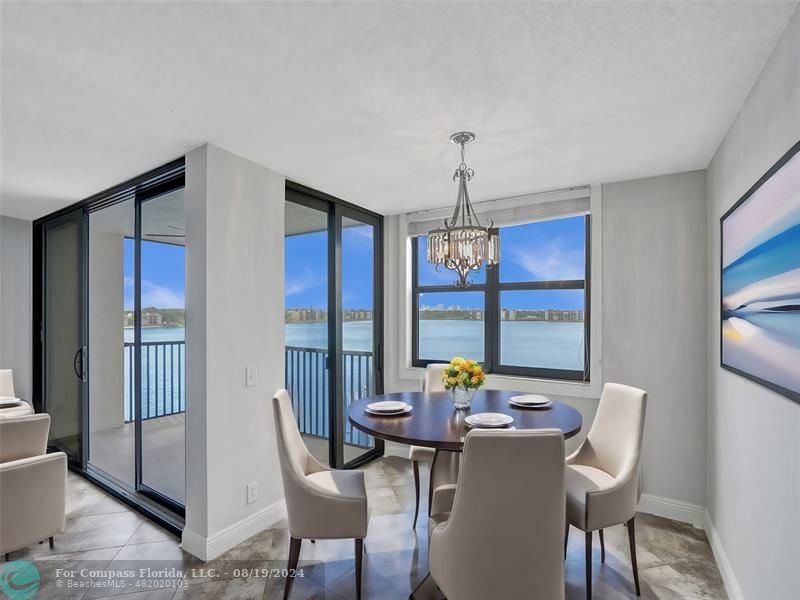 a dining room with furniture a chandelier and window