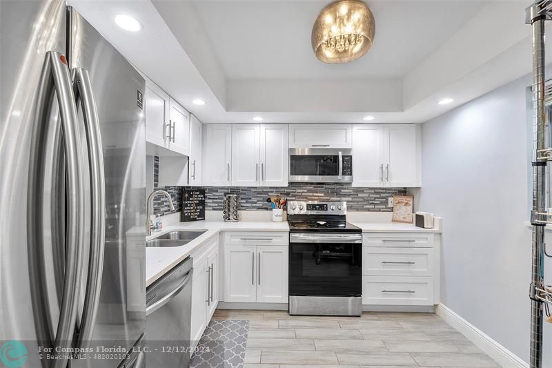 a kitchen with stainless steel appliances a stove a sink and a refrigerator