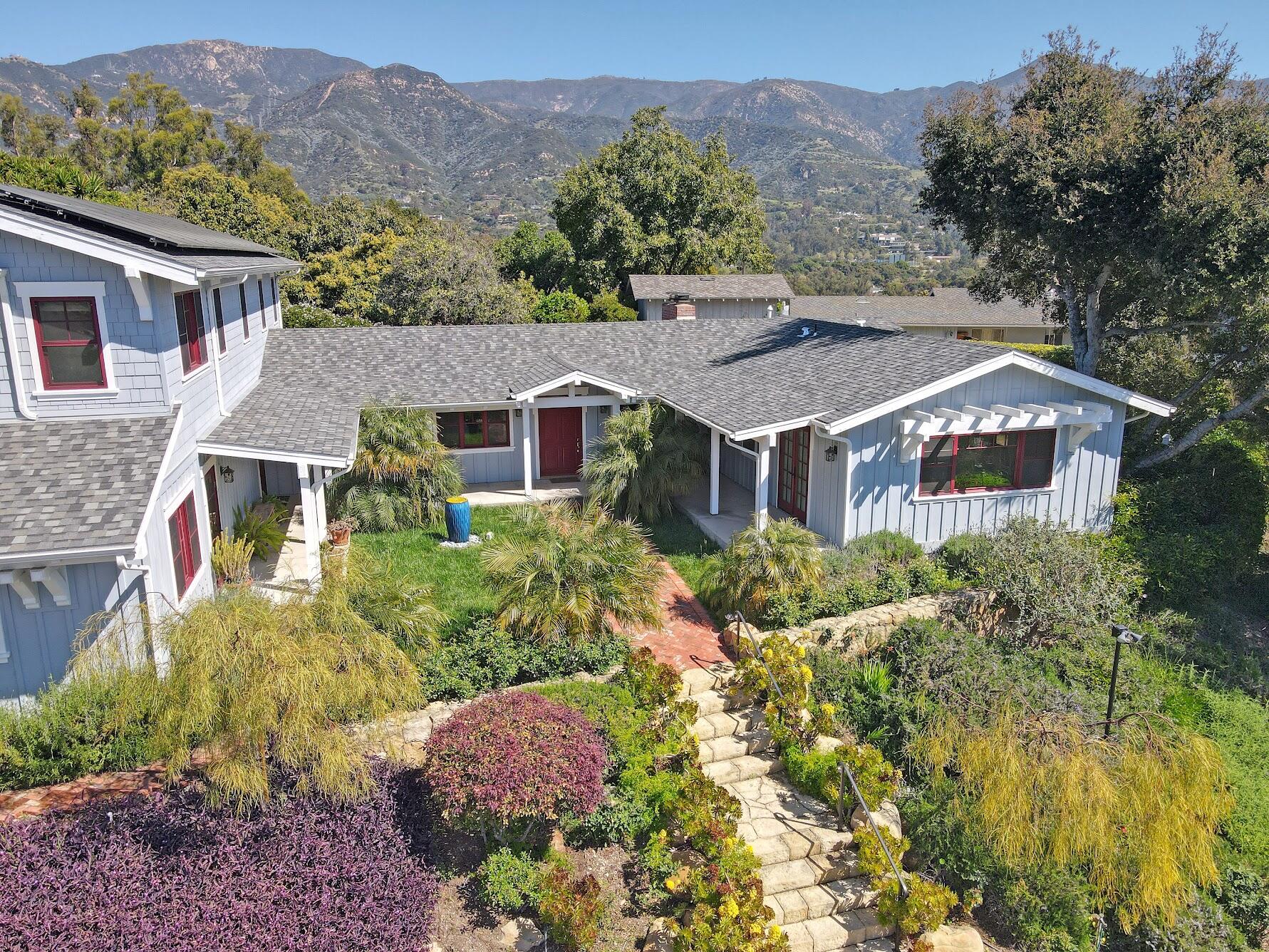 a aerial view of a house with a yard and a large tree