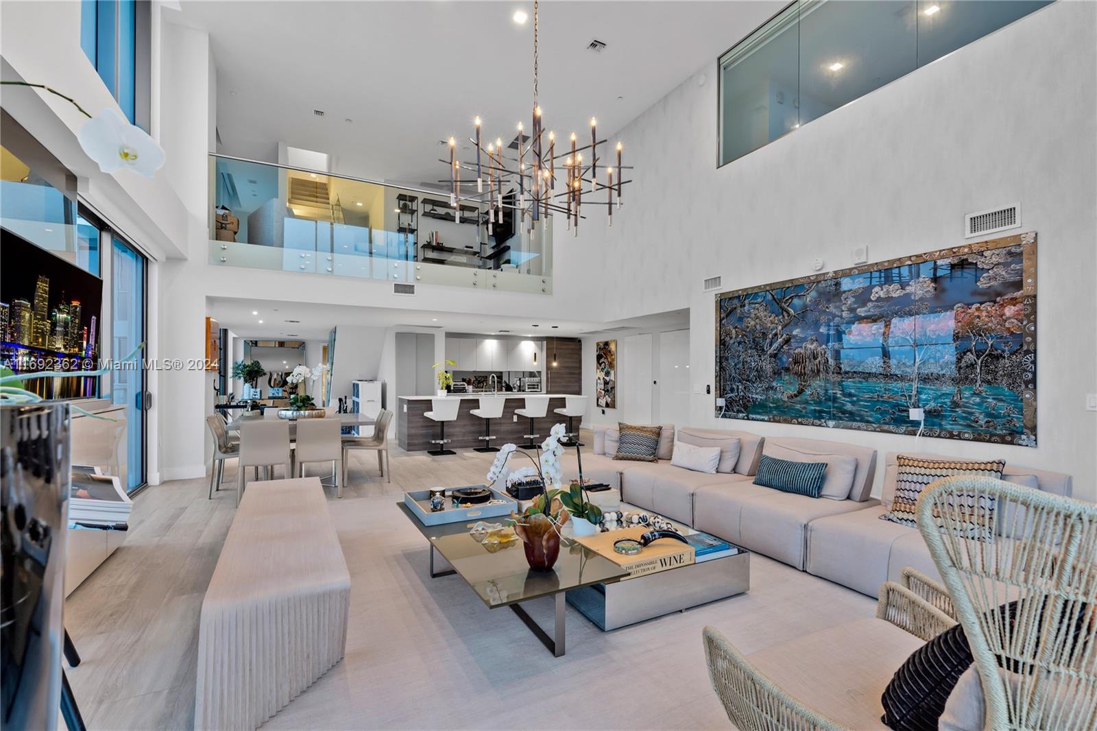 a living room with furniture a chandelier and a flat screen tv