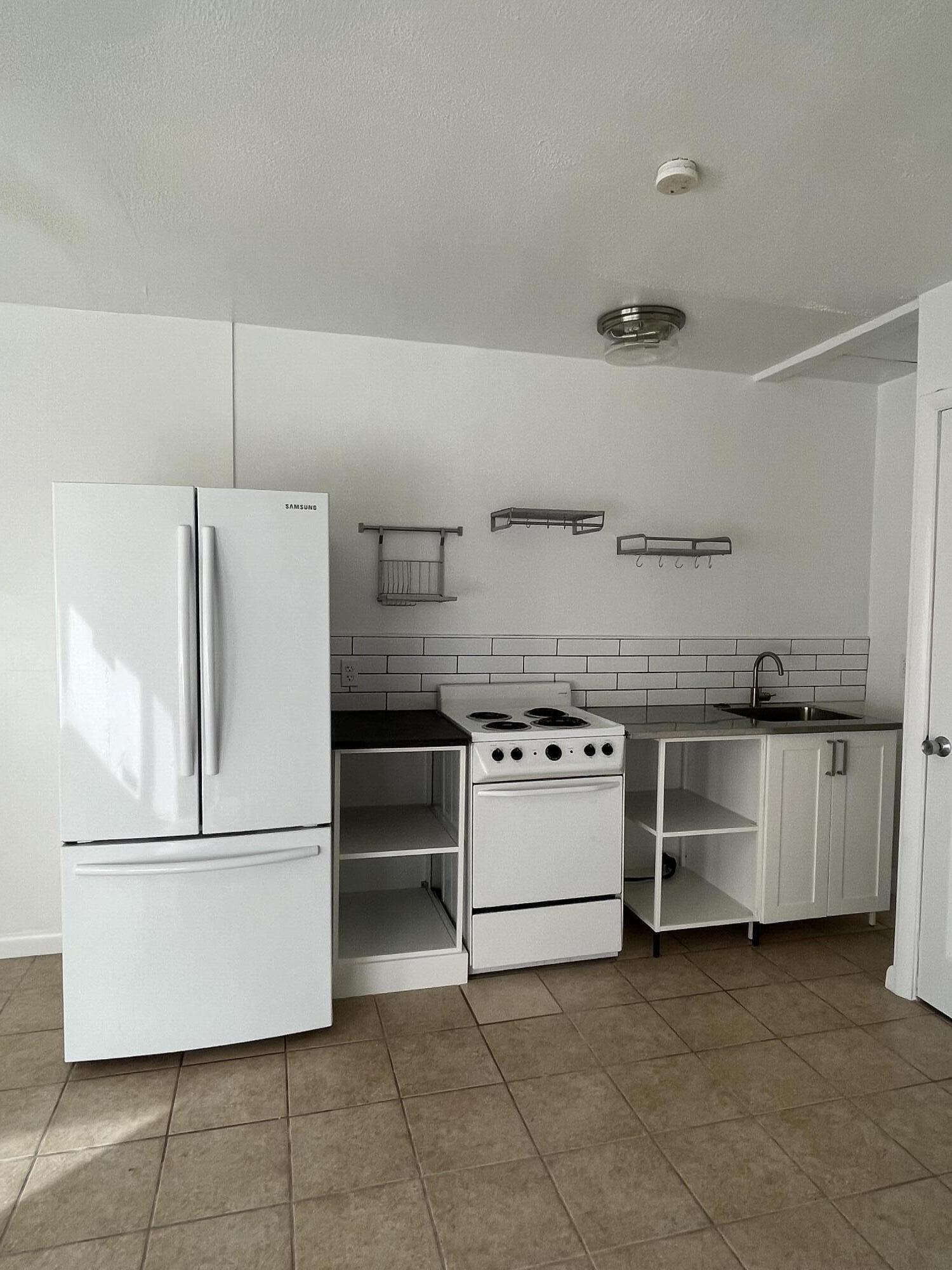 a kitchen with a stove top oven and refrigerator