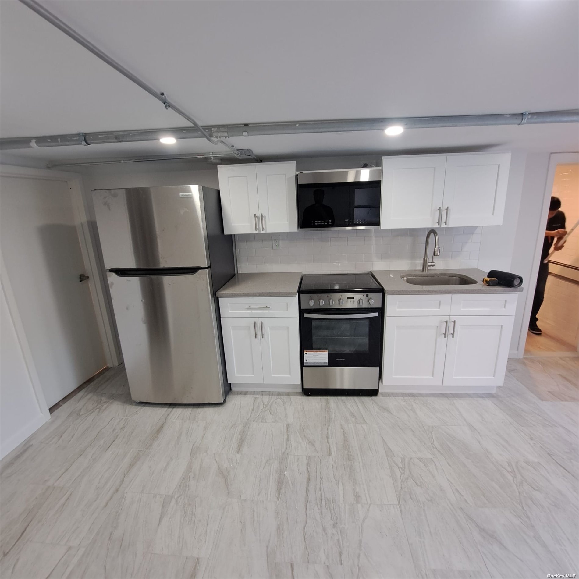 a kitchen with stainless steel appliances a refrigerator sink and microwave