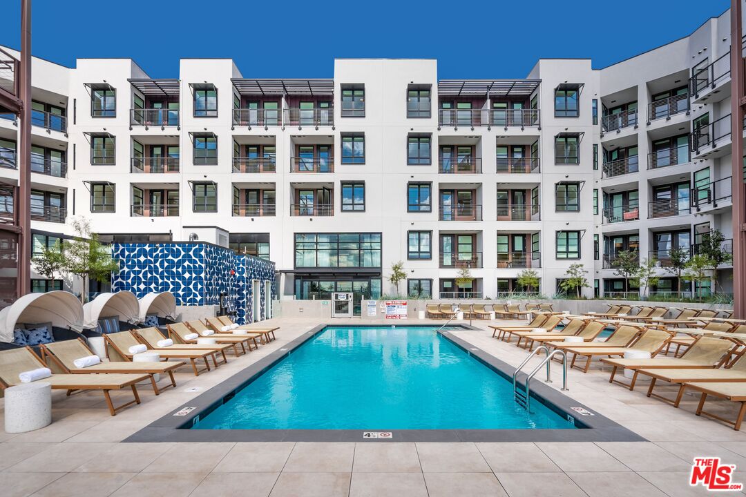 a front view of a building with swimming pool and outdoor seating