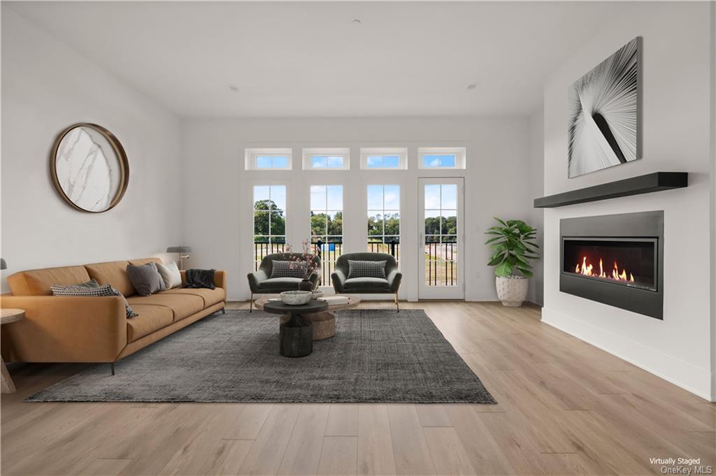 a living room with furniture floor to ceiling window and a fireplace