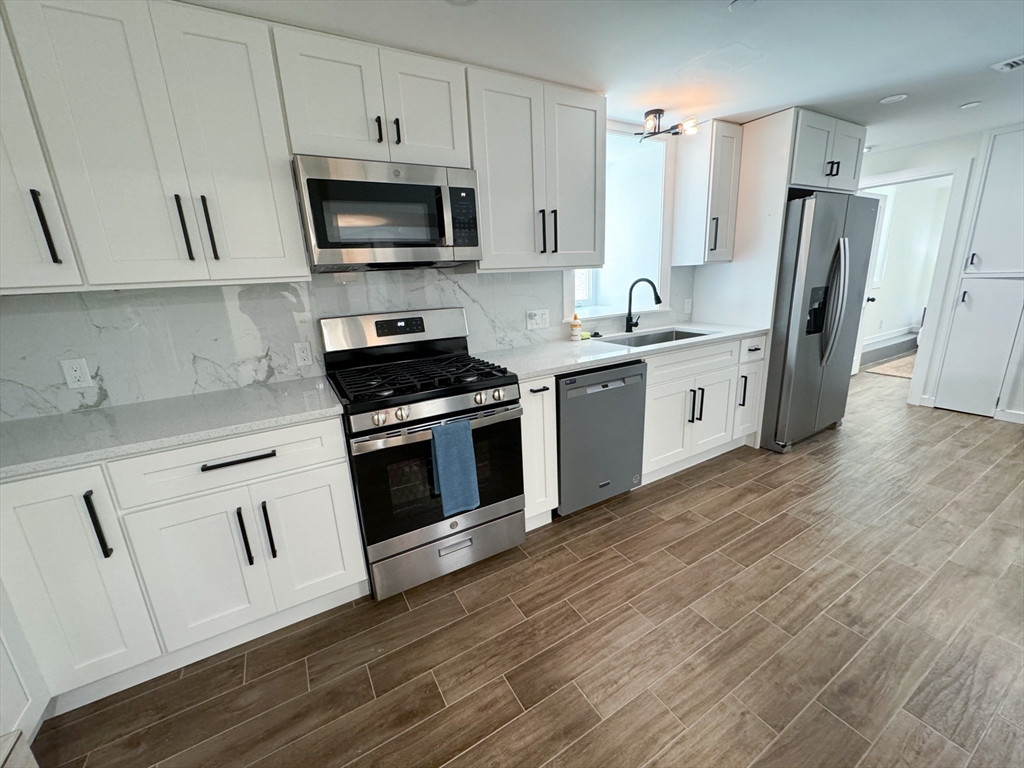 a kitchen with stainless steel appliances a stove a sink and a microwave