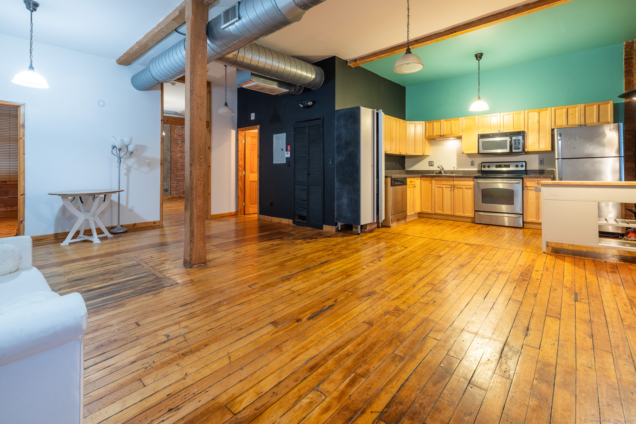 a view of a kitchen with kitchen island a sink wooden floor and a large window