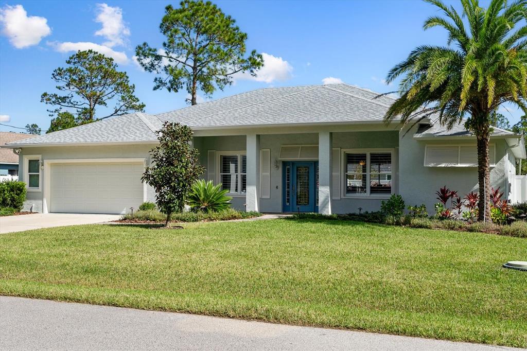 a view of a house with a yard and palm trees