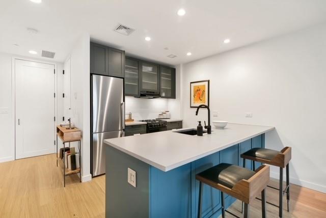 a kitchen with refrigerator and chairs