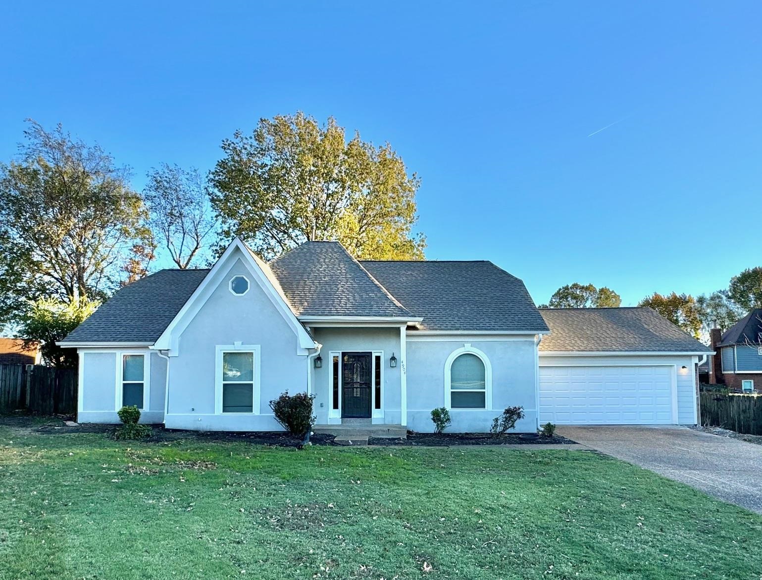 View of front of home featuring a front yard and a garage