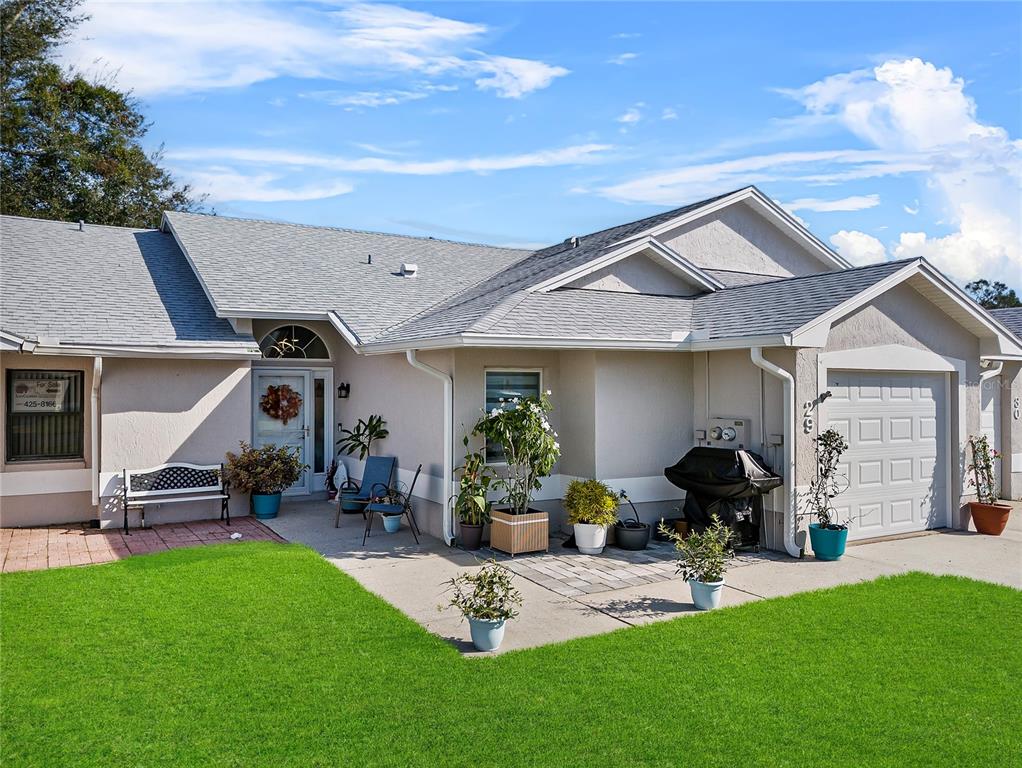 a front view of a house with garden and sitting area